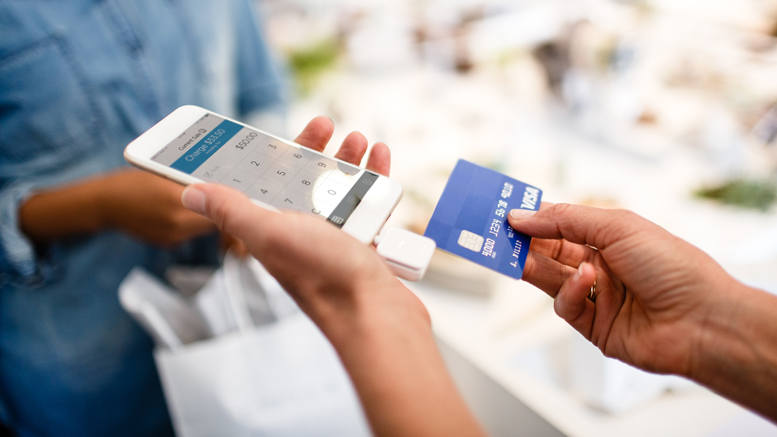 merchant-purchase-mobile-1600x900 Merchant using a mobile phone to complete a transaction