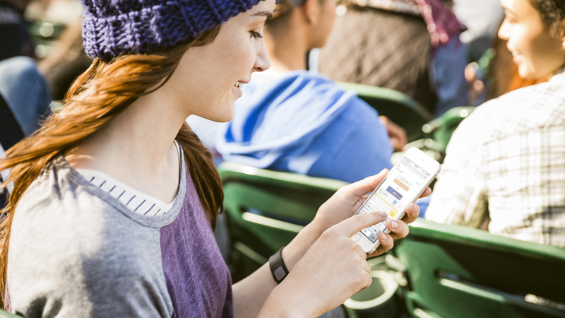 Woman looking at her mobile phone with Visa Checkout on the screen. Woman looking at her mobile phone with Visa Checkout on the screen.